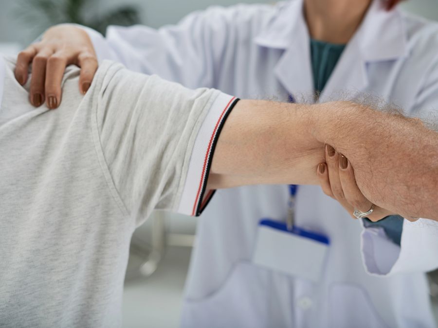Clinician gently mobilising a patient's arm and shoulder joint
