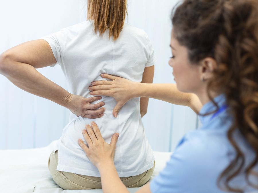 Physiotherapist assessing a patient's lower back pain