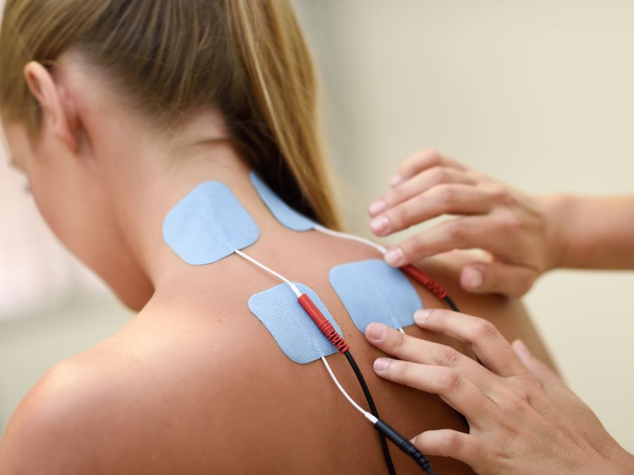 Electrotherapy pads applied to a patient's shoulder and upper back