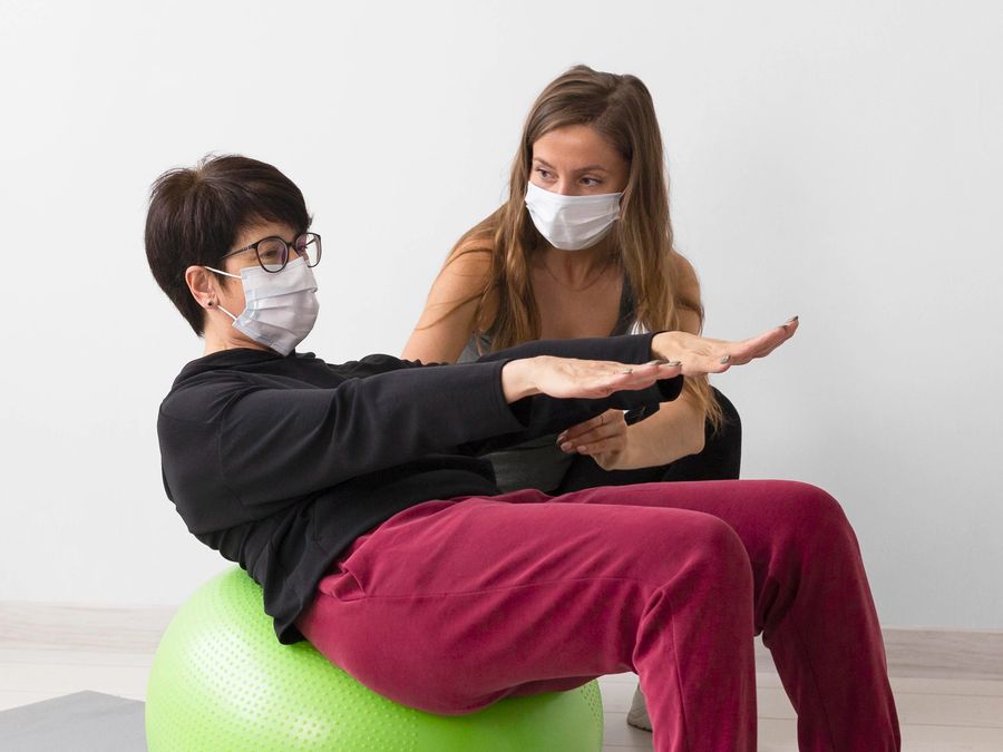 Physiotherapist guiding exercises with a patient at home
