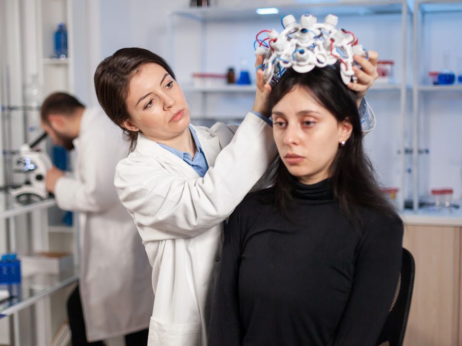 Clinician fitting a patient with neurological assessment equipment