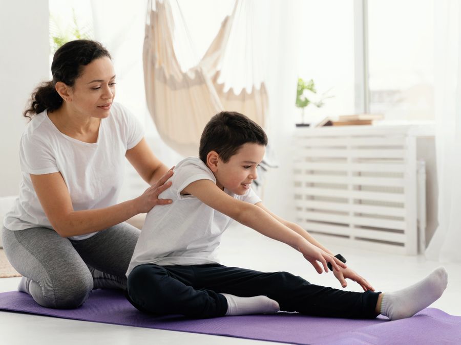 Therapist working through stretches with a child on an exercise mat